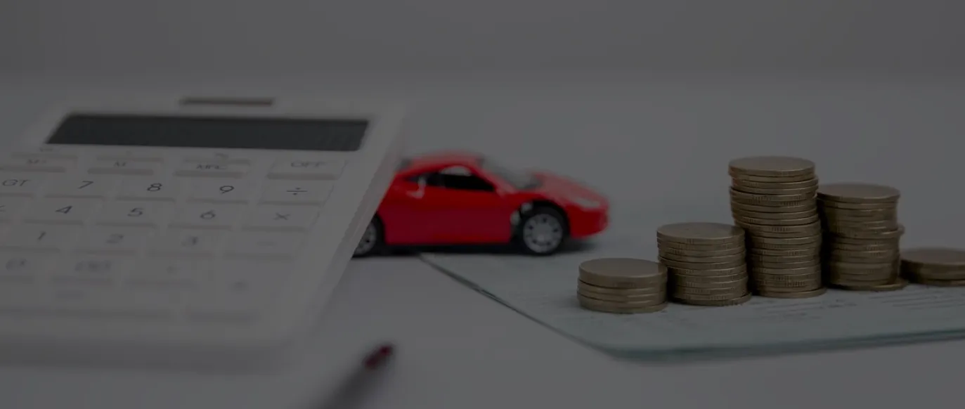 pénzérmék felsorakoztatva számológép és autó mellett