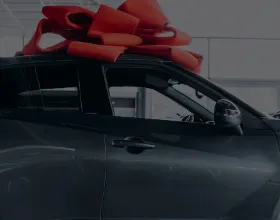 szürke autó piros masnival gépjármű ajándékozáskor